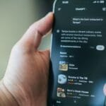 A hand uses chatgpt on a phone for restaurant recommendations.