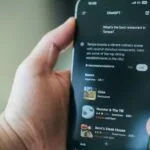 A hand uses chatgpt on a phone for restaurant recommendations.