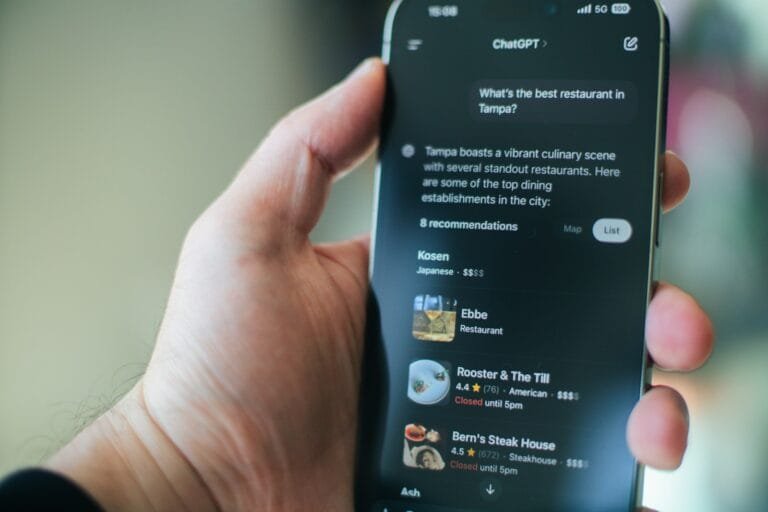 A hand uses chatgpt on a phone for restaurant recommendations.